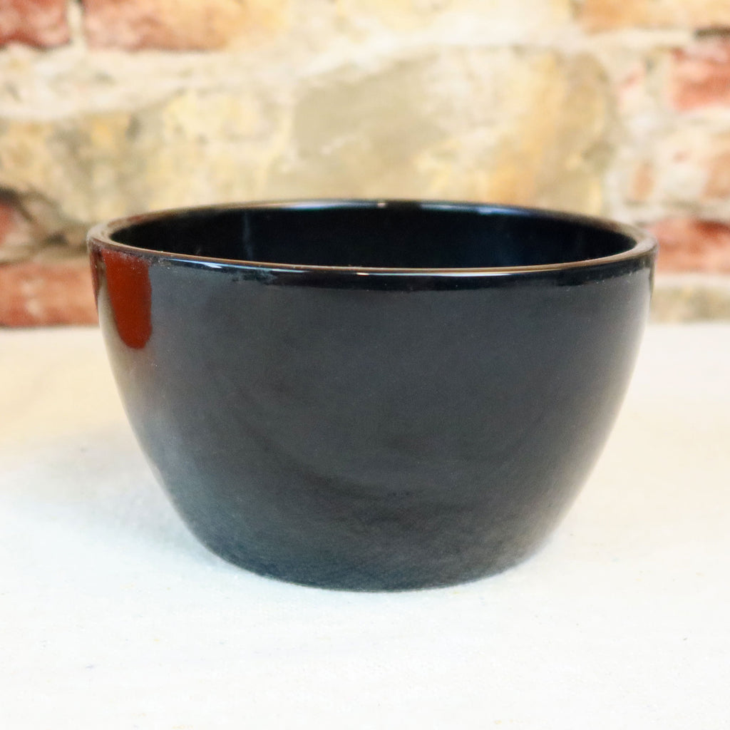 Ceramic Garden Bowl in multiple colors on a light surface, shown as a stylish indoor or outdoor planter with stone wall behind.