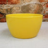 Ceramic Garden Bowl displayed on a light surface with a rustic brick wall, suitable as an indoor or outdoor planter. Available in 9 colors.