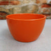 Orange Ceramic Garden Bowl displayed on a light surface with a blurred stone and brick wall background, suitable as an indoor-outdoor planter.